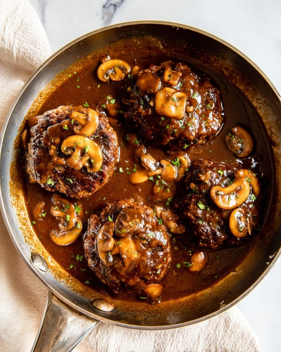 The image shows a close-up of three thick, round burger patties covered in rich, dark brown mushroom sauce, served in a shiny metal pan. The patties are topped with soft, cooked mushroom slices that have a light brown color with a slightly glossy texture. The sauce around the patties is thick and smooth, with a deep brown color and some small bits of herbs sprinkled on top for a touch of green. The pan is set on a white marbled surface, adding a clean and bright contrast to the dark, hearty dish. Photo taken with an iphone --ar 4:5 --v 7