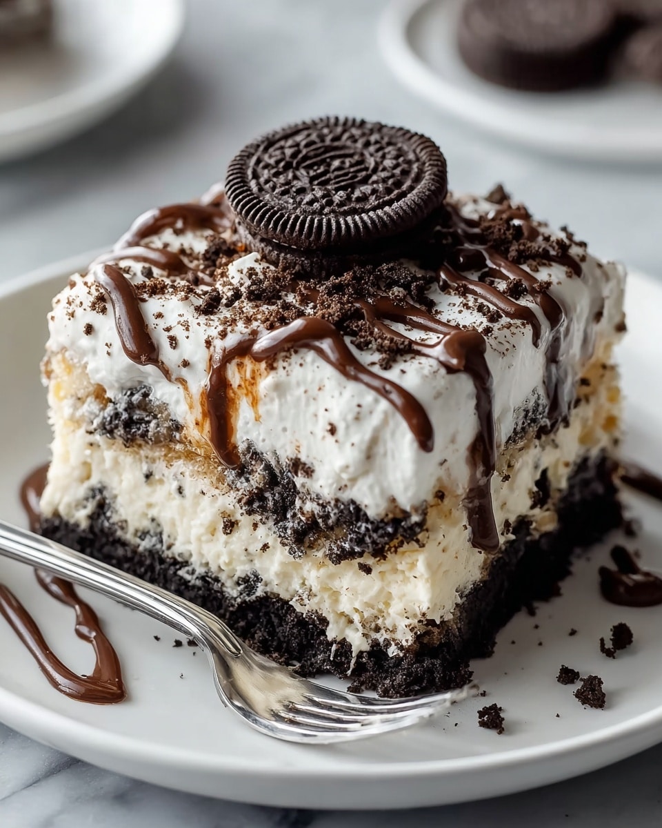 A square piece of layered dessert sits on a white plate, with three visible layers: the bottom layer is dark and crumbly, consisting of crushed cookies; the middle layer is creamy white with cookie crumbs mixed in; the top layer is thick, white, and fluffy, sprinkled with more crushed dark cookies and drizzled with glossy chocolate sauce in thin lines; on top, a whole dark cookie sits at the center as a garnish; a silver fork rests beside the dessert, and the background is a white marbled texture. photo taken with an iphone --ar 4:5 --v 7